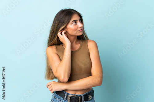 Young caucasian woman isolated on blue background thinking an idea