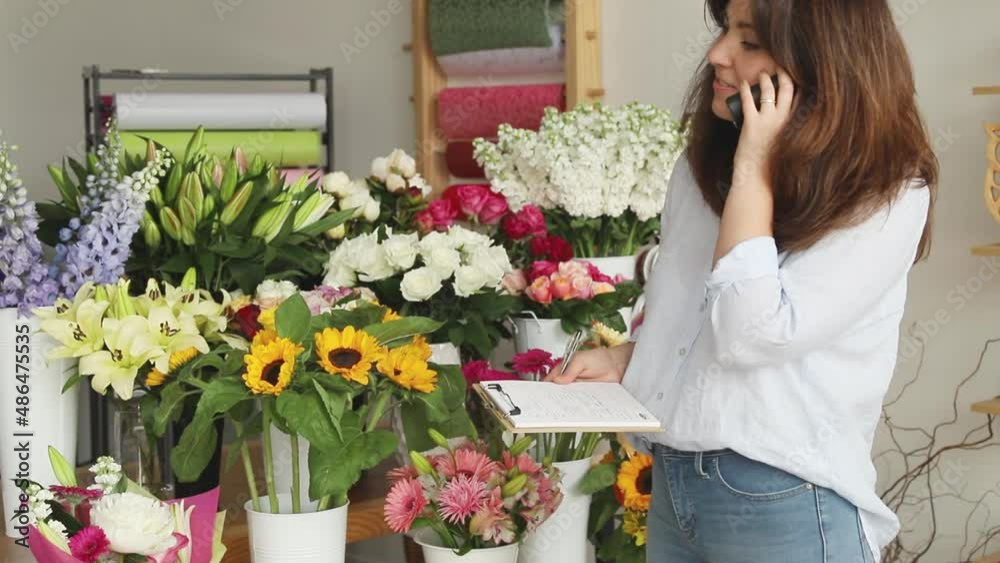 Small business. Female florist unfocused in flower shop. Floral design studio, making decorations and arrangements. Flowers delivery, creating order. Small business. Female florist unfocused in flower shop. Floral design studio, making decorations and arrangements. Flowers delivery, creating order.