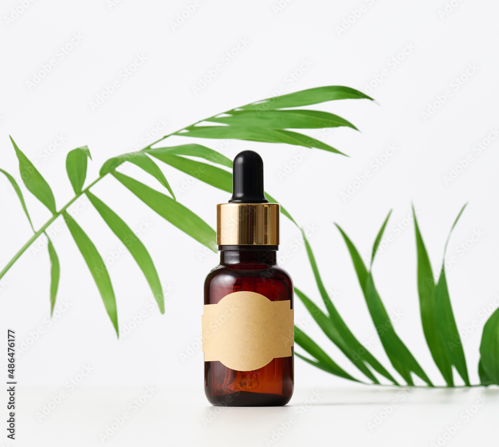brown glass bottle with paper empty label and pipette. Cosmetic packaging, advertising and promotion brown glass bottle with paper empty label and pipette. Cosmetic packaging, advertising and promotion