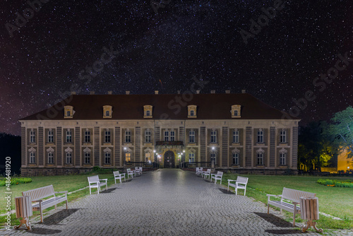 Pałac książęcy w mieście Żagań w Polsce w nocnej scenerii. Czyste, bezchmurne niebo rozświetlone jest gwiazdami.