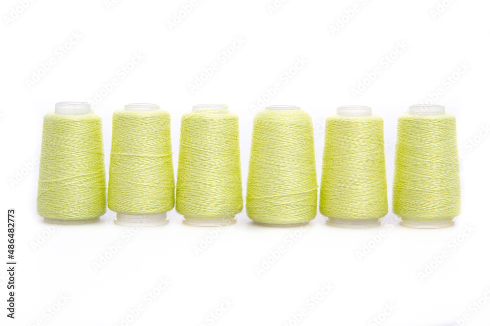 Yellow spool of thread isolated on white background. Skein of woolen threads. Yarn for knitting. Materials for sewing machine. Coil Yellow spool of thread isolated on white background. Skein of woolen threads. Yarn for knitting. Materials for sewing machine. Coil
