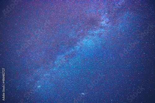 Nocne, bezchmurne pokryte gwiazdami niebo z widoczną wyraźnie galaktyką.