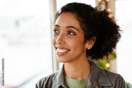 Young black woman wearing shirt smiling indoors