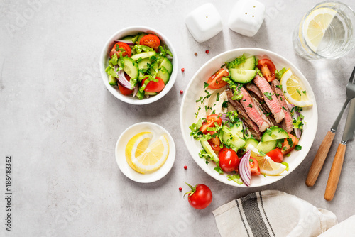 Fresh salad and creamy hummus are topped with veggies and perfectly grilled steak in this Mediterranean Steak Bowl. top view