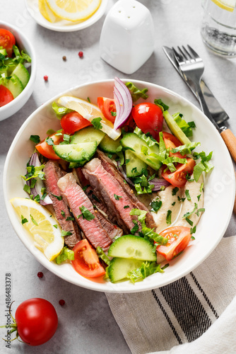 Fresh salad and creamy hummus are topped with veggies and perfectly grilled steak in this Mediterranean Steak Bowl.