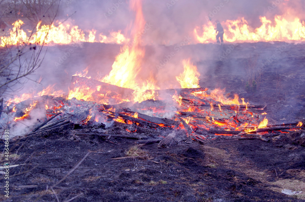 Strażak gaszący pożar. Konwekcja rozgrzanego powietrza i dymu rozmywa widok. Strażak gaszący pożar. Konwekcja rozgrzanego powietrza i dymu rozmywa widok.