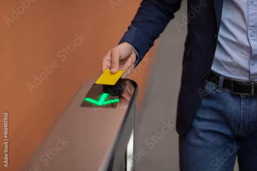 Unrecognizable man holding electronic entrance gate card, closeup