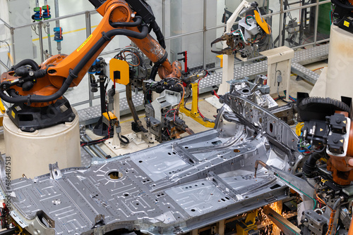 Photo of automobile production line. Welding car body. Modern car assembly plant. Auto industry. Interior of a high-tech factory, modern production