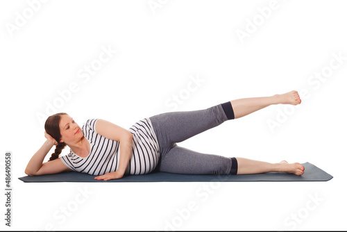 Pregnancy yoga exercise - pregnant woman doing yoga asana Vishnuasana Easy Side Reclining Leg Lift Pose isolated on white background