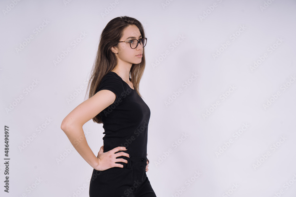 Young Female model in studio. high fashion portrait of young elegant woman. skinny black pants, black heels shoes. Young Female model in studio. high fashion portrait of young elegant woman. skinny black pants, black heels shoes.