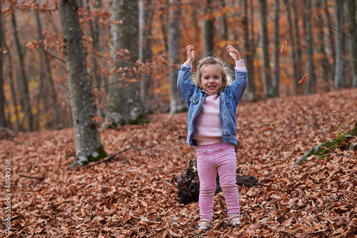 little girl in autumn forest with yellow foliage