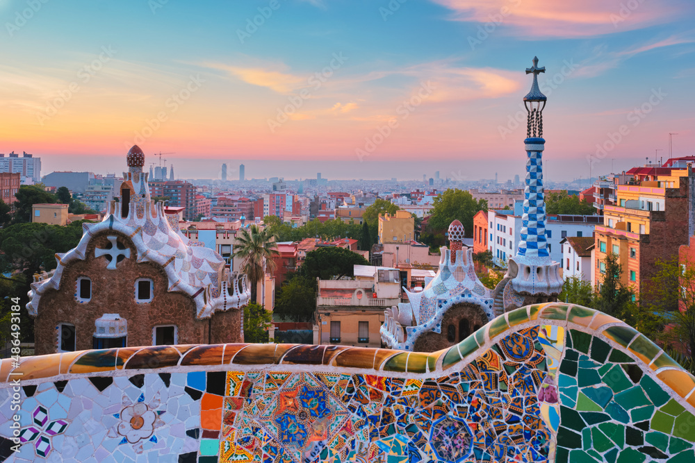 Obraz premium Barcelona city view from Guell Park with colorful mosaic buildings in tourist attraction Park Guell in the morning on sunrise. Barcelona, Spain