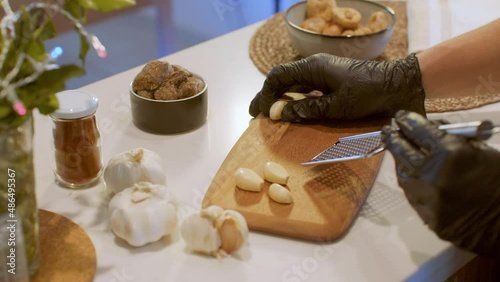 Fresh Garlic Crushed in the grater on the Wooden Cutting Board