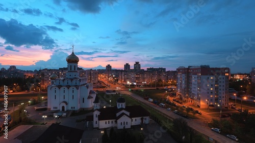 Change Day To Night Transition Traffic On Street And Multi-storey Residential Houses. Cityscape Minsk Skyline With Russian Orthodox Church. 4K Cloudy Sky With Clouds In Motion Above Multi-storey