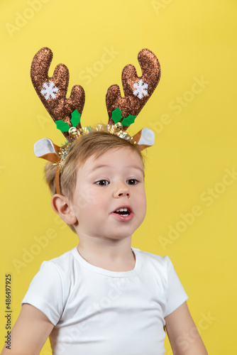 Cute boy in in christmas reindeer costume making funny faces