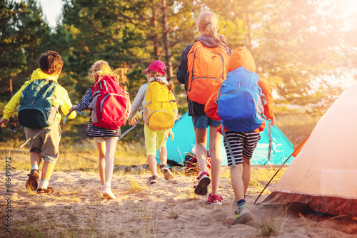 Group of the children with backpacks on the nature near the sea.