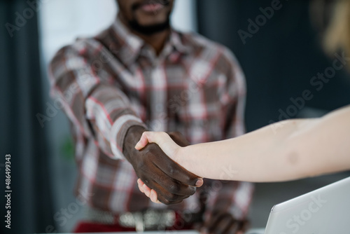 Hands of multi-ethnic people shaking in greeting or agreement, african american man and caucasian man shaking hands. Handshake of people different ethnicities. Business concept