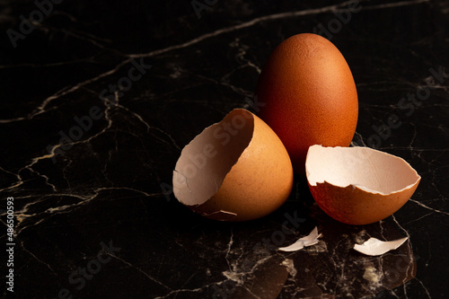 Chicken fresh egg and shell close-up on a dark marble background photo