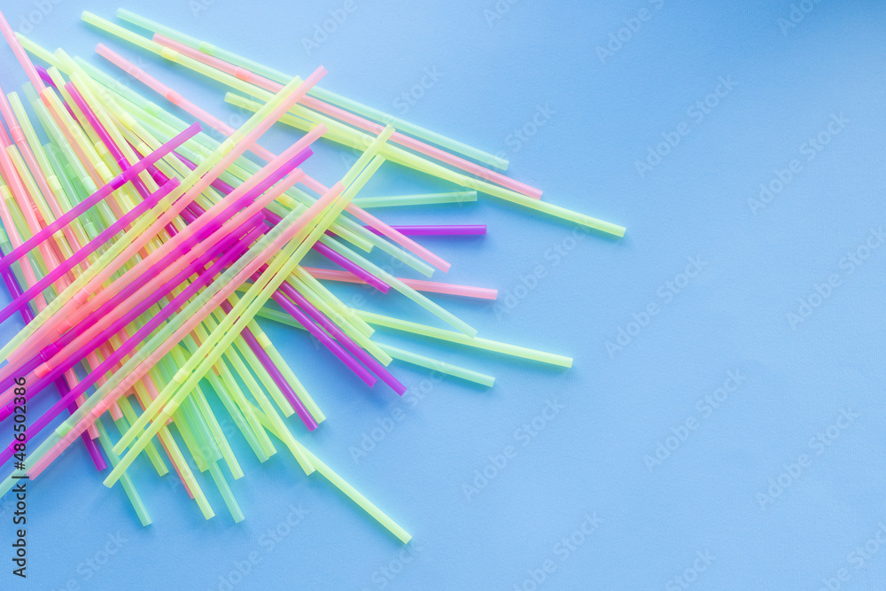 Colored plastic drinking straws on a blue background