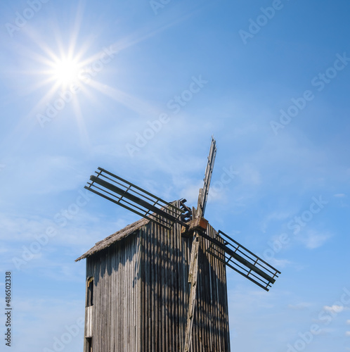 closeup winmill on sunny sky background, historical authentical scene photo