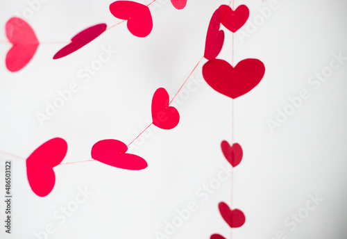 red and pink  hearts on red threads on a white background