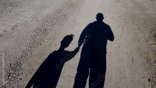 two human shadows, human figures walking on the road,