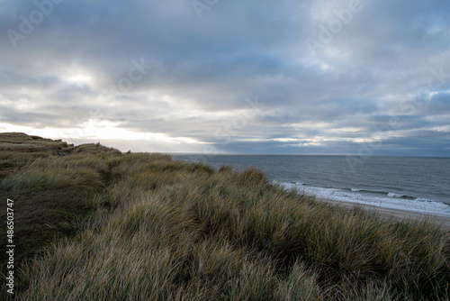 Die Abendsonne scheint durch die Regenwolken am Meer