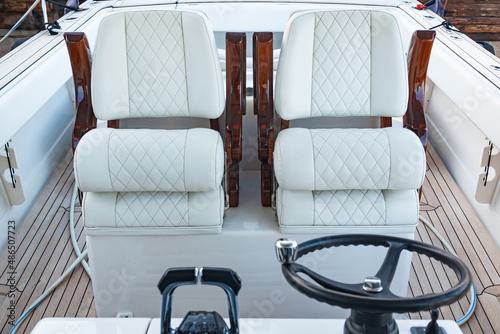 Fototapeta Luxury motorboat control cabin with white leather seats, steering wheel and gear lever