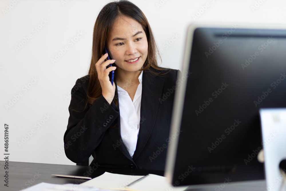 Business woman talking on the phone during online meeting and working on computer. Business woman talking on the phone during online meeting and working on computer.