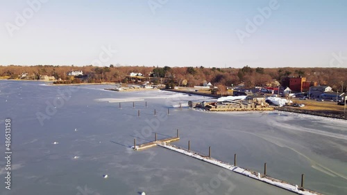 Aerial footage flying over frozen harbor at Hingham MA. Forward motion. photo