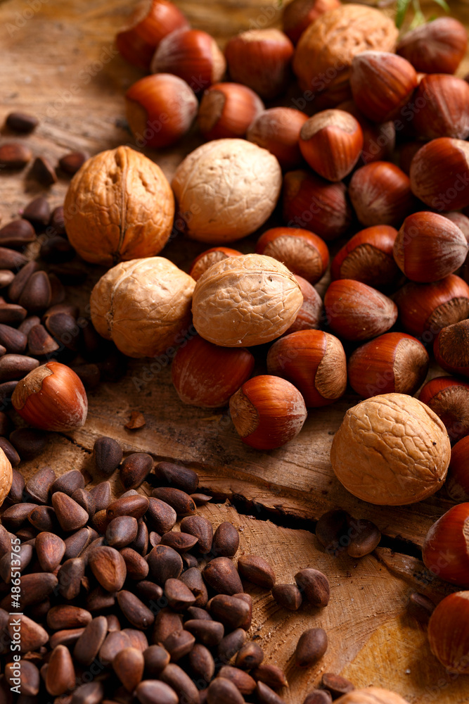 Siberian pine nuts, hazelnuts and walnuts on wooden board Siberian pine nuts, hazelnuts and walnuts on wooden board
