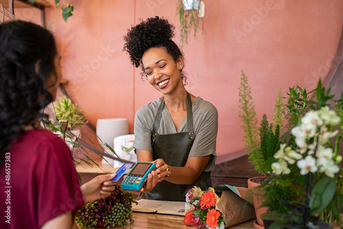 Customer paying with contactless credit card at flower shop photo