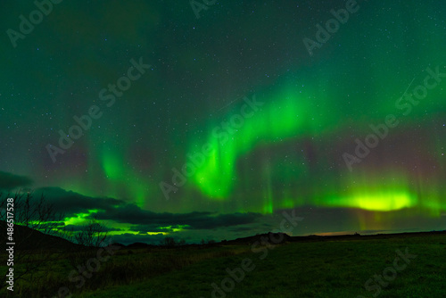 Aurora Borealis over the landscape and teh water. © Ineke