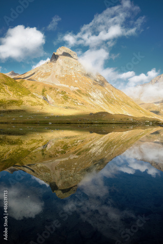 lake with mountains and clouds reflection on water. Tranquil nature landscape. Lake with calm water and reflections