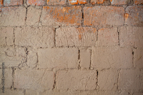 Repair of an old brick wall of a home stove. Different red bricks are laid in the wall after repair. Brick background