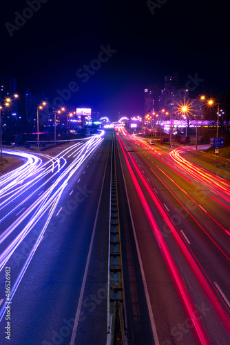 Night city traffic. Light trails from cars moving along the road. Light trails from fast moving cars at night