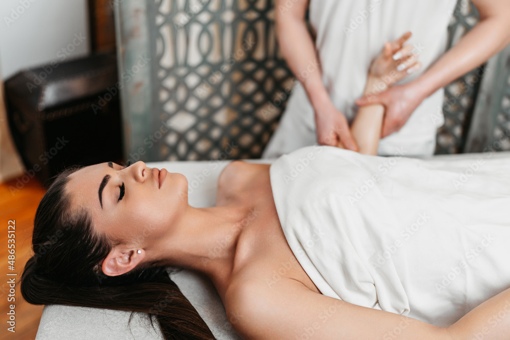 Fototapeta premium Beautiful young woman receiving professional body massage treatment with aromatherapy essential oil.