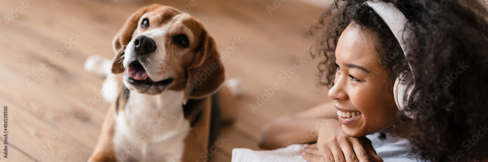 Young african woman in casual wear with beagle puppy