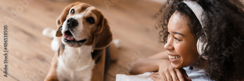 Young african woman in casual wear with beagle puppy