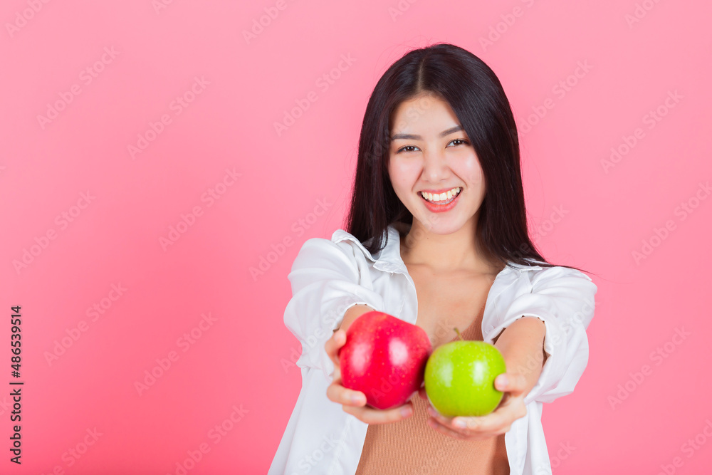 asian woman happy holding green apple and red apple. asian woman happy holding green apple and red apple.