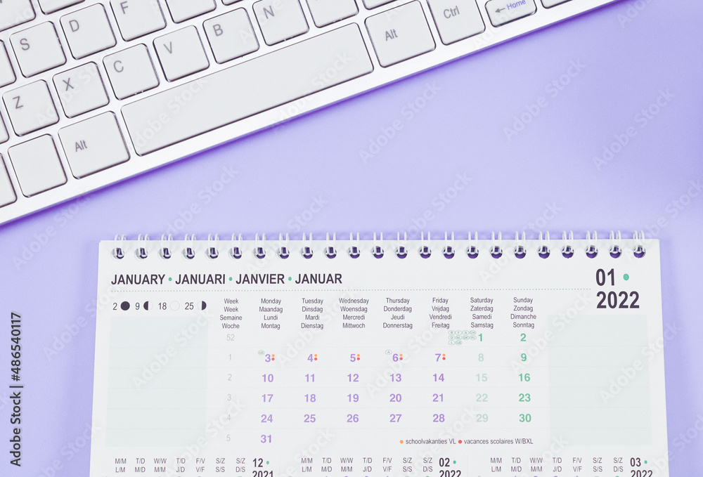 Calendar for January 2022 with the keyboard lie on a light lilac background. Calendar for January 2022 with the keyboard lie on a light lilac background.