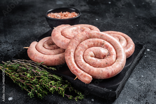 Fotografija Traditional Raw spiral sausages on a marble board with thyme