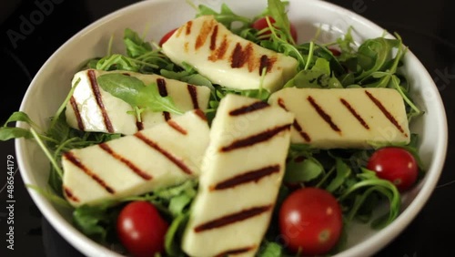 Grilled halloumi cheese salad with arugula and cherry tomatoes photo