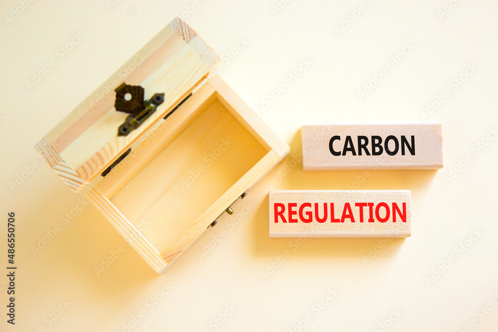 Carbon regulation symbol. Concept words Carbon regulation on wooden blocks on a beautiful white table white background. Empthy wooden chest. Business and carbon regulation concept, copy space. Carbon regulation symbol. Concept words Carbon regulation on wooden blocks on a beautiful white table white background. Empthy wooden chest. Business and carbon regulation concept, copy space.