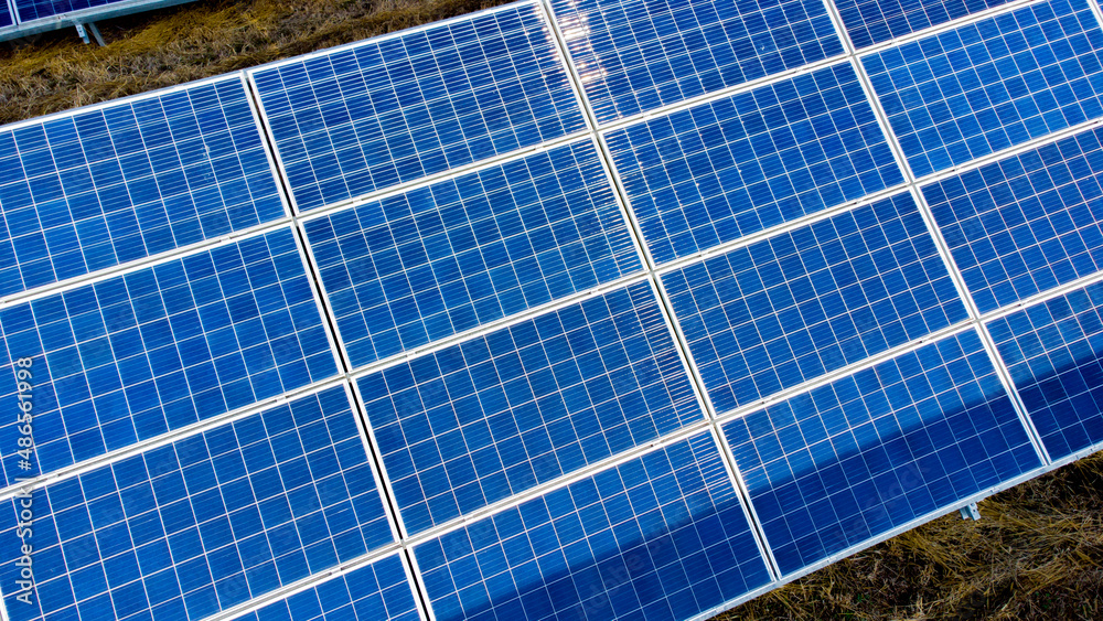 Aerial drone view flight over solar power station panels. Aerial top view of solar farm. Green energy, electrical innovation. Renewable Energy. Industrial Solar Energy Farm producing solar power. Aerial drone view flight over solar power station panels. Aerial top view of solar farm. Green energy, electrical innovation. Renewable Energy. Industrial Solar Energy Farm producing solar power.