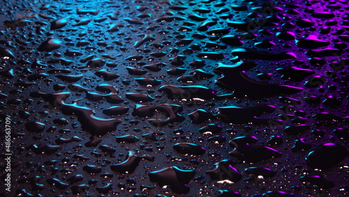 Drops and stains of water in the dark blue purple color background selective focus