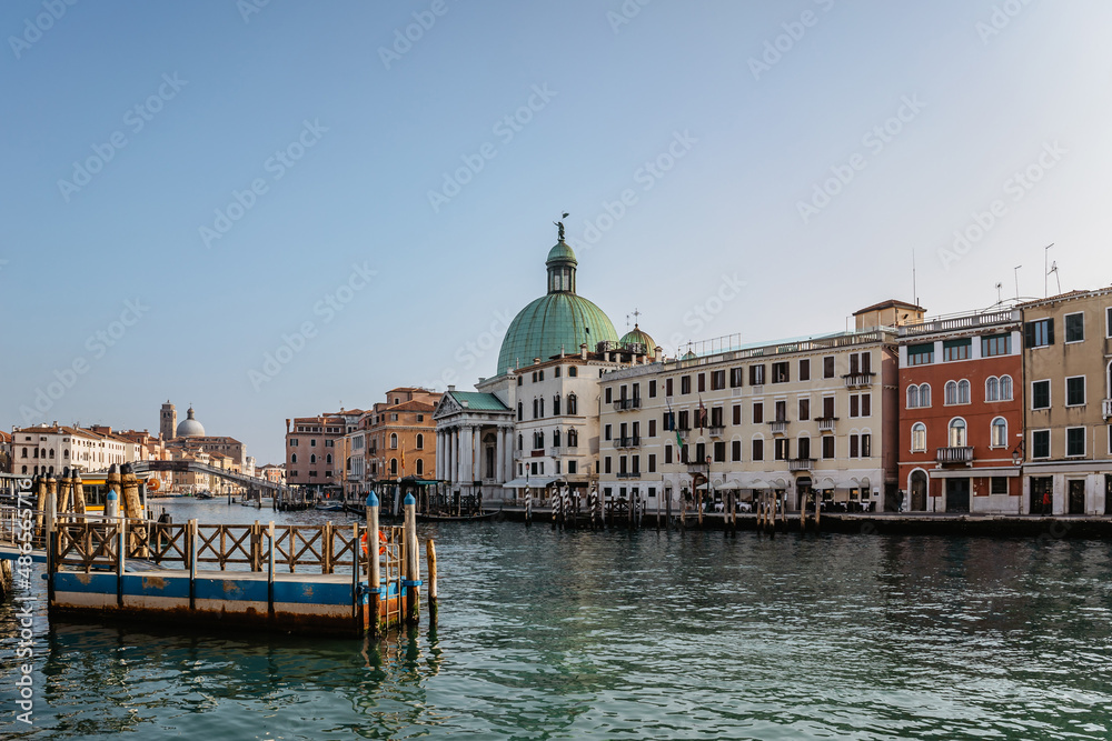 Grand Canal,Venice,Italy.Typical boat transportation.View of vaporetto station,Venetian public waterbus.Water transport.Travel urban scene.Popular tourist destination.Old houses, church along canal