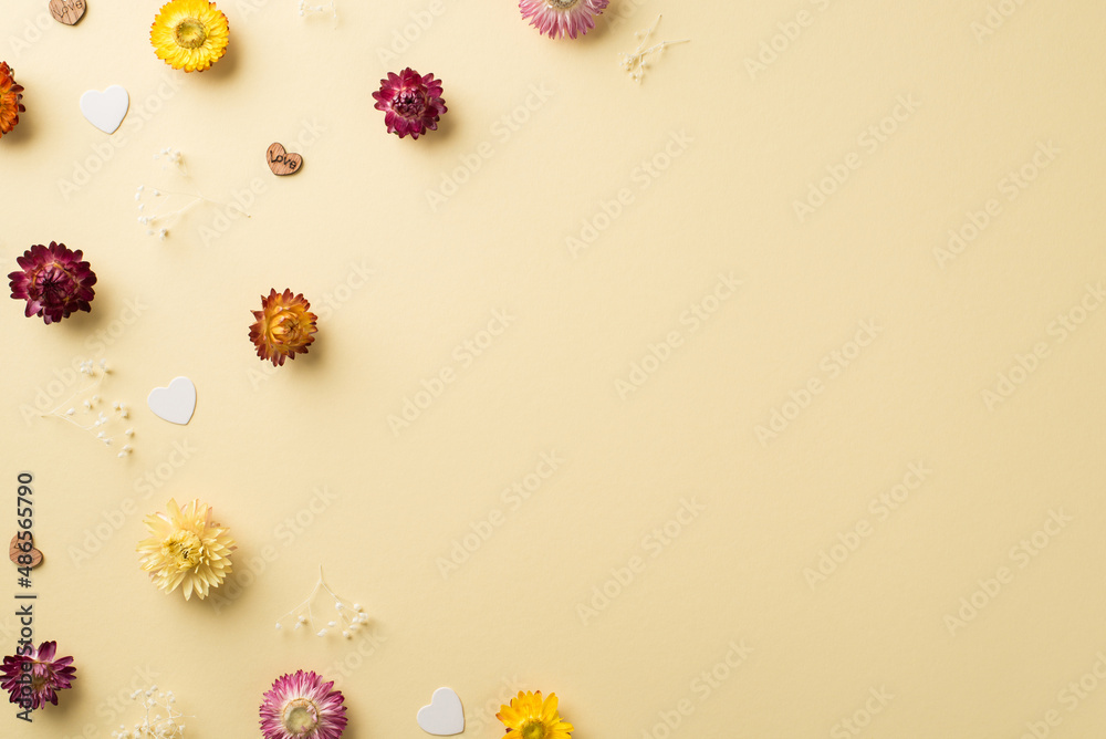 Naklejka premium Top view photo of woman's day composition different color wild flowers and hearts on isolated beige background with copyspace