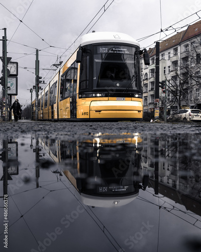 Spiegelung einer Tram in einer Pfütze an der Schönhauser Allee in Berlin