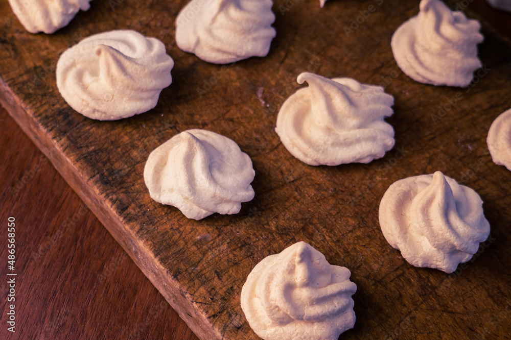 Delicious crispy homemade egg meringue, prepared with love on a wooden background, crunchy dessert for coffee or tea. Delicious crispy homemade egg meringue, prepared with love on a wooden background, crunchy dessert for coffee or tea.